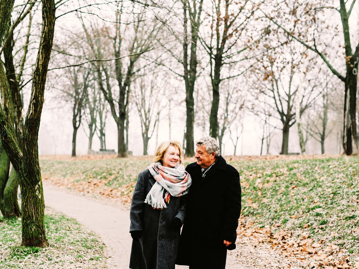 An older couple walking an autumn avenue