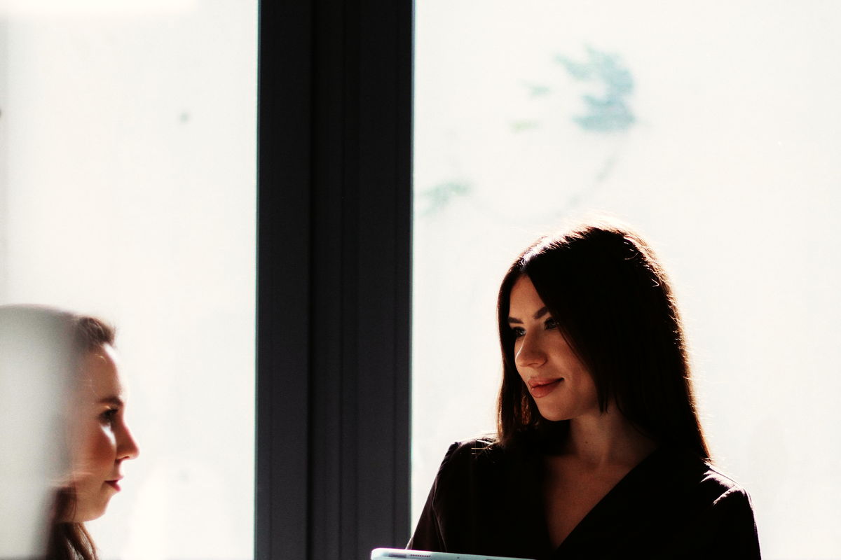 Two colleagues in conversation by a window